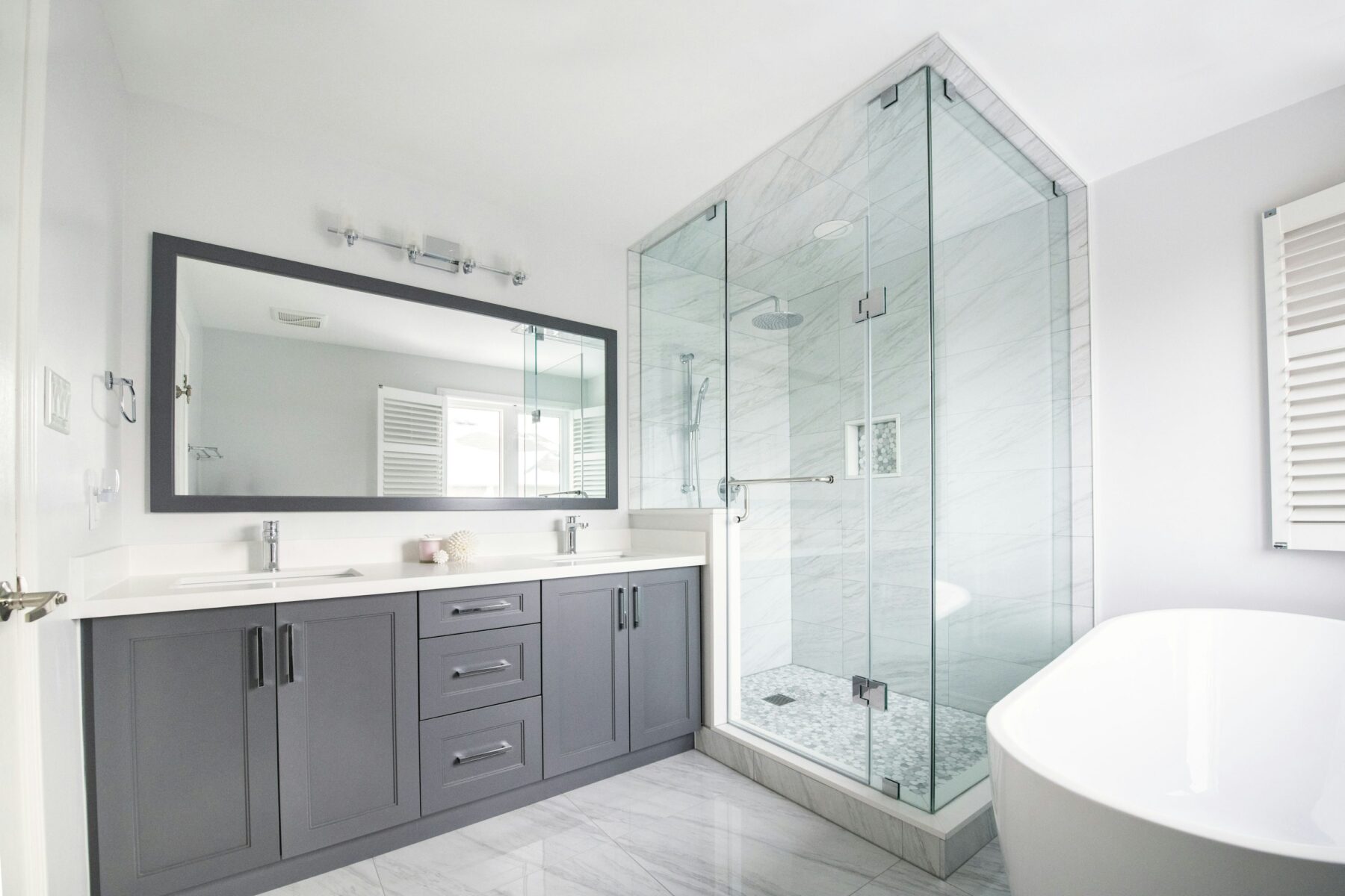 Bright ensuite with double vanity, glass shower and freestanding bathtub