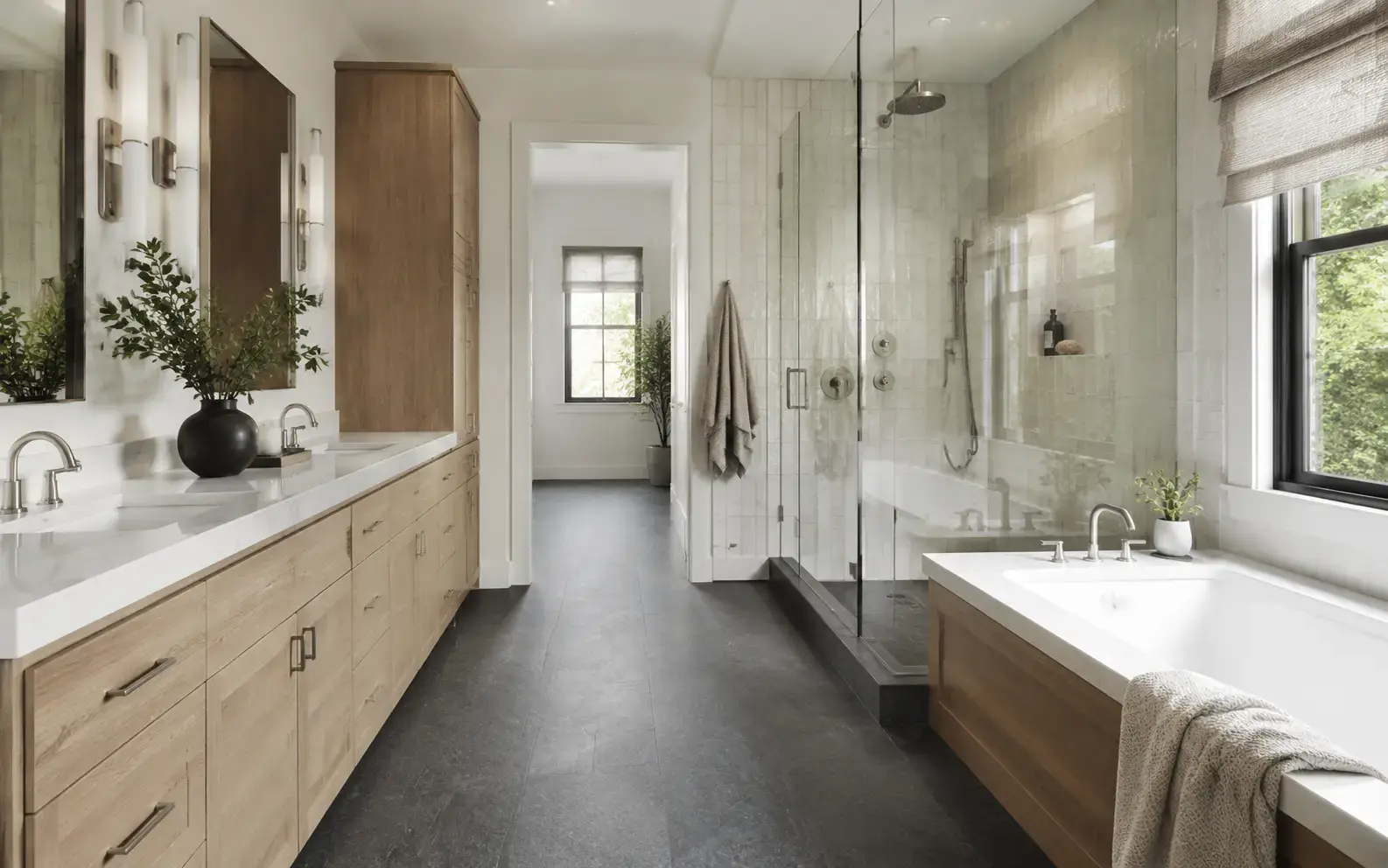 Complete bathroom with charcoal floor, oak cabinetry and softly textured zellige shower walls
