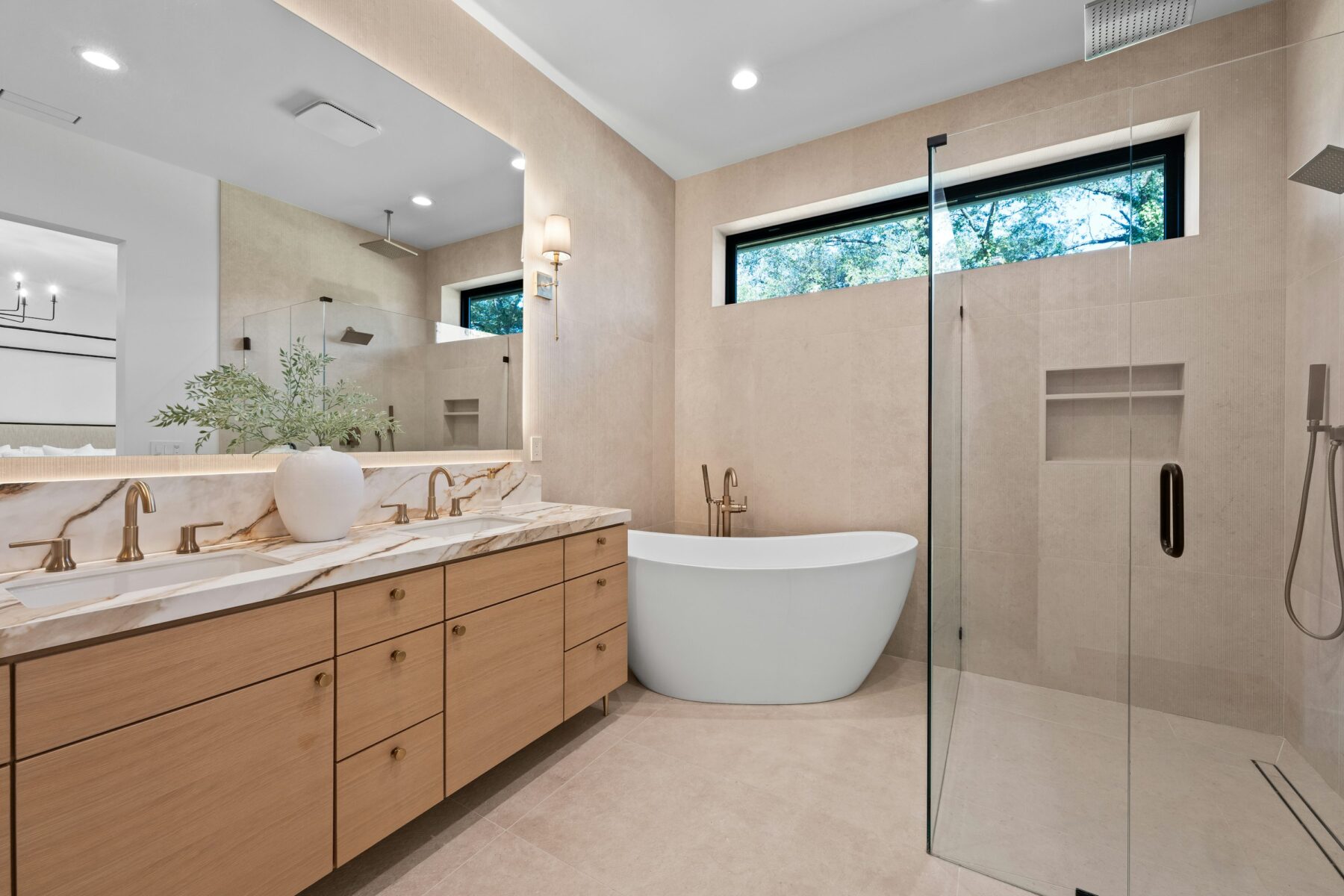 Warm contemporary bathroom with oak double vanity, freestanding tub and frameless walk-in shower